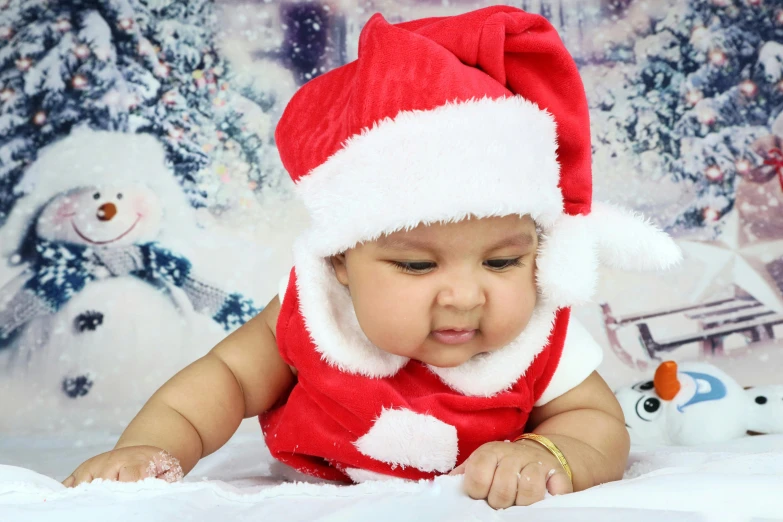 a baby wearing a santa hat laying on a bed, pexels, process art, vinayak, square, looking from side, fashionable