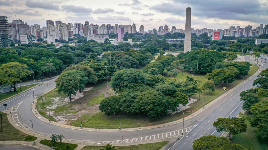 a view of a city from a bird's eye view, by Felipe Seade, with a park in the background, monument, edu souza, trees around