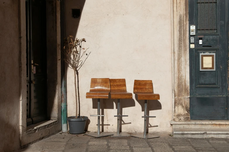 a couple of wooden benches sitting on top of a sidewalk, by Romain brook, les nabis, cocktail bar, 6 0 s chair, medium, harsh sunlight