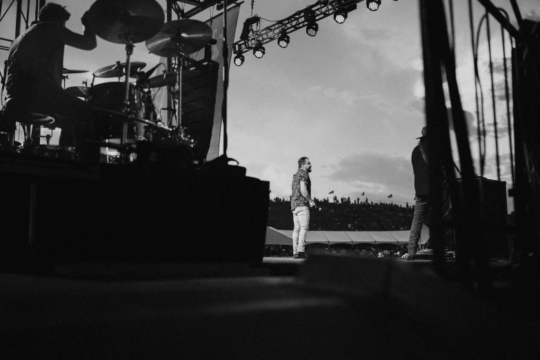 a group of people standing on top of a stage, a black and white photo, unsplash, linkin park, photo taken on fujifilm superia, on the field, kyle mclaughlin