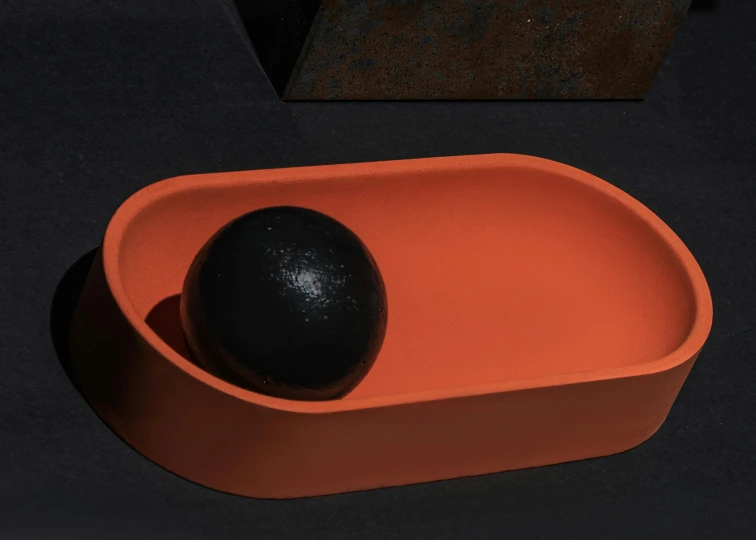 an orange bowl with an avocado in it, an abstract sculpture, inspired by Isamu Noguchi, unsplash, figuration libre, all black matte product, rectangular, backscatter orbs, lacquered