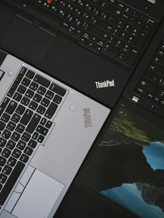 a couple of laptops sitting next to each other, trending on unsplash, thinkpad, low quality photo, high angle close up shot, ( ( theatrical ) )