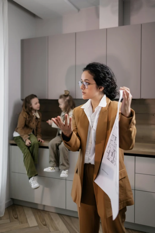 a woman standing in a kitchen next to a window, kid and mad scientist walking, professor clothes, woman holding another woman, profile image