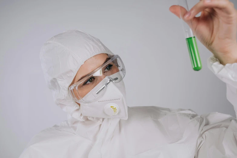 a man in a lab coat holding a test tube, by Adam Marczyński, pexels contest winner, photograph of a techwear woman, a green, masked doctors, clean white lab background