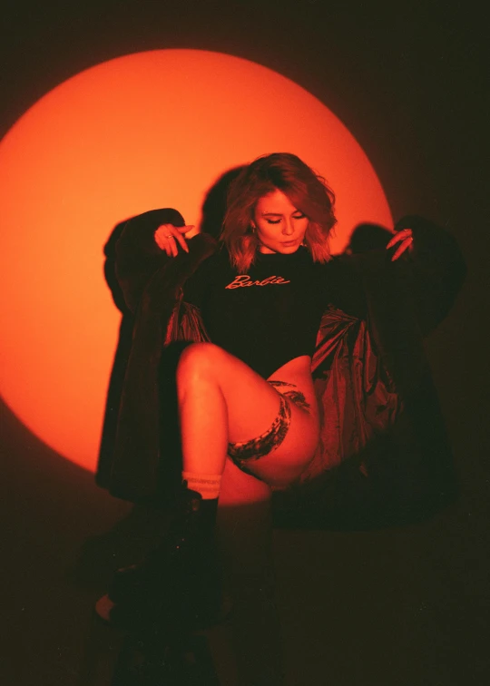 a woman is posing in front of the sun, an album cover, inspired by Elsa Bleda, realism, orange and red lighting, sydney sweeney, badass pose, cl