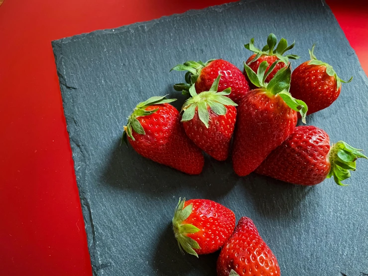 a bunch of strawberries sitting on top of a cutting board, inspired by Louise Bourgeois, pexels contest winner, crisp details, red hearts, bottom angle, exterior shot