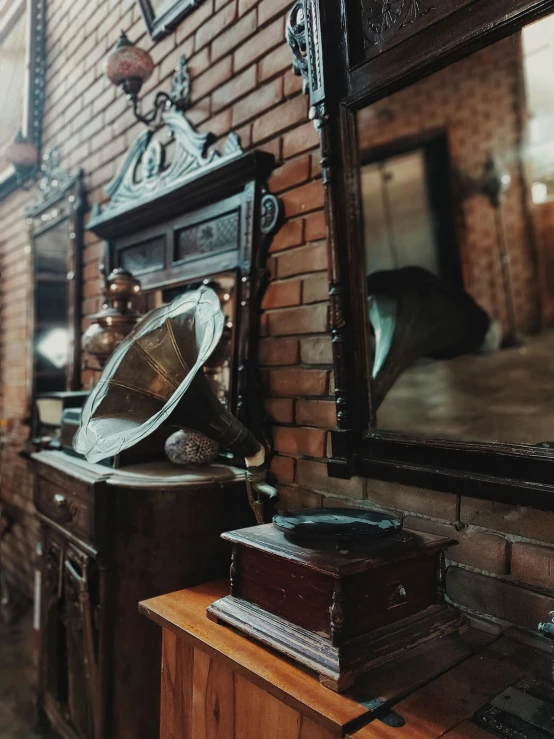 a room filled with lots of furniture next to a brick wall, an album cover, pexels contest winner, view from behind mirror, antique piece, background image, steampunk aesthetic