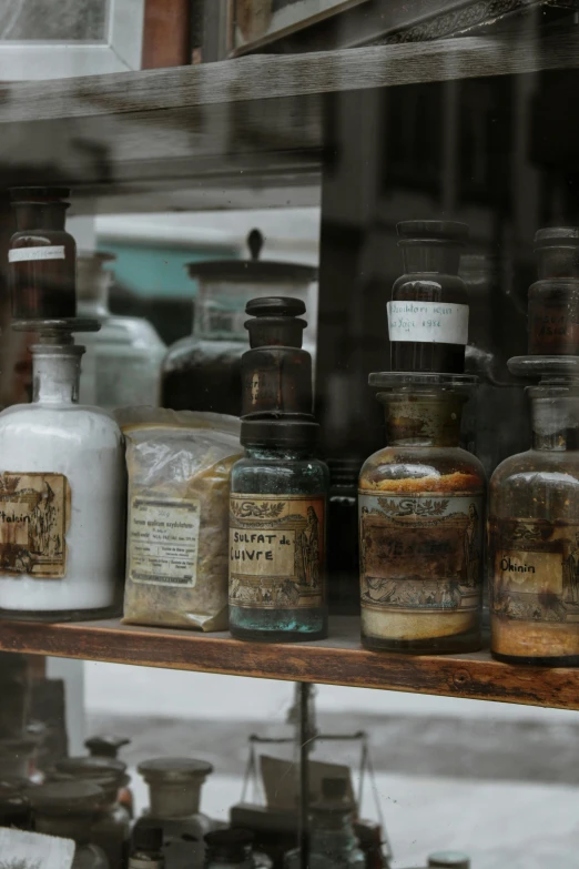 a bunch of bottles that are on a shelf, a still life, unsplash, renaissance, doctors mirror, preserved historical, storefront, brown