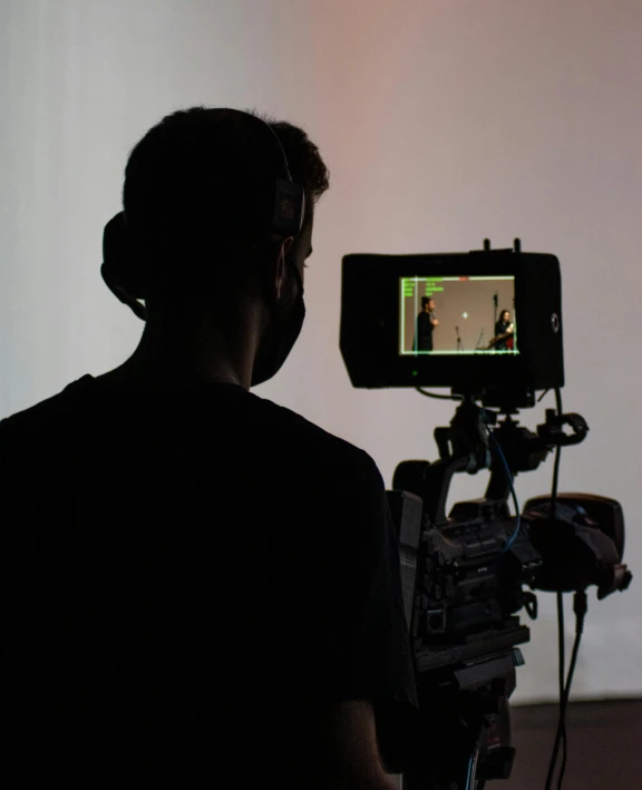 a man that is standing in front of a camera, pexels, video art, facing away from the camera, theatre equipment, promo image, casting