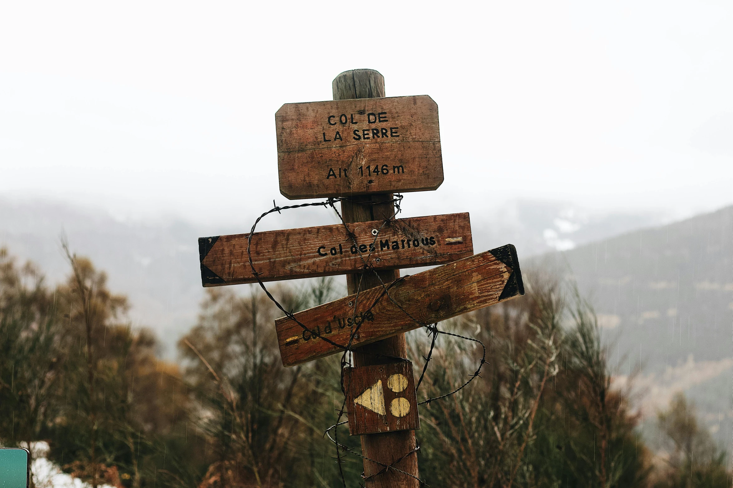 a wooden sign sitting on the side of a road, unsplash, trecking, thumbnail, multi-part, brown