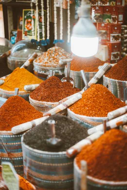 a market filled with lots of different types of spices, sand particles, black and orange colour palette, silver, tall