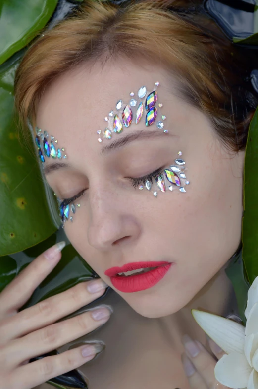 a close up of a woman with glitter on her face, an album cover, inspired by Julia Pishtar, aestheticism, white facepaint, crystal-embellished, biophilia, glitter sticker