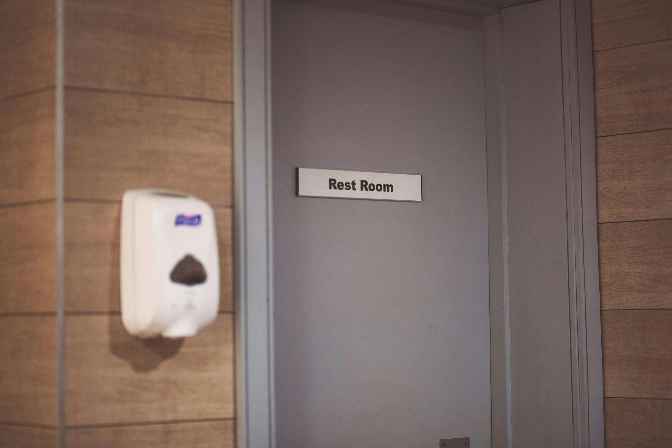 a bathroom with a toilet paper dispenser on the wall, by Rachel Reckitt, pexels, square, closed limbo room, commercial, grey