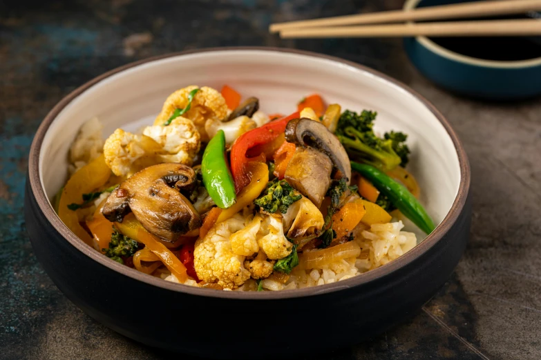 a close up of a bowl of food with chopsticks, vegetables, 'groovy', medium wide front shot, exotic wonder