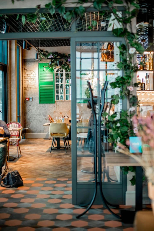 a woman sitting at a table in a restaurant, inspired by Albert Paris Gütersloh, unsplash, archways made of lush greenery, gemmy woud - binendijk, panoramic shot, seasonal