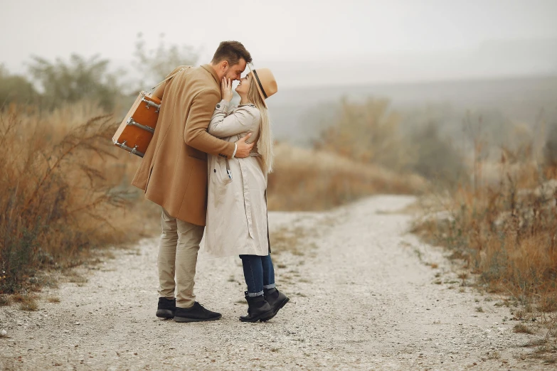 a man and a woman kissing on a dirt road, pexels contest winner, straw hat and overcoat, picnic, fall season, hugging