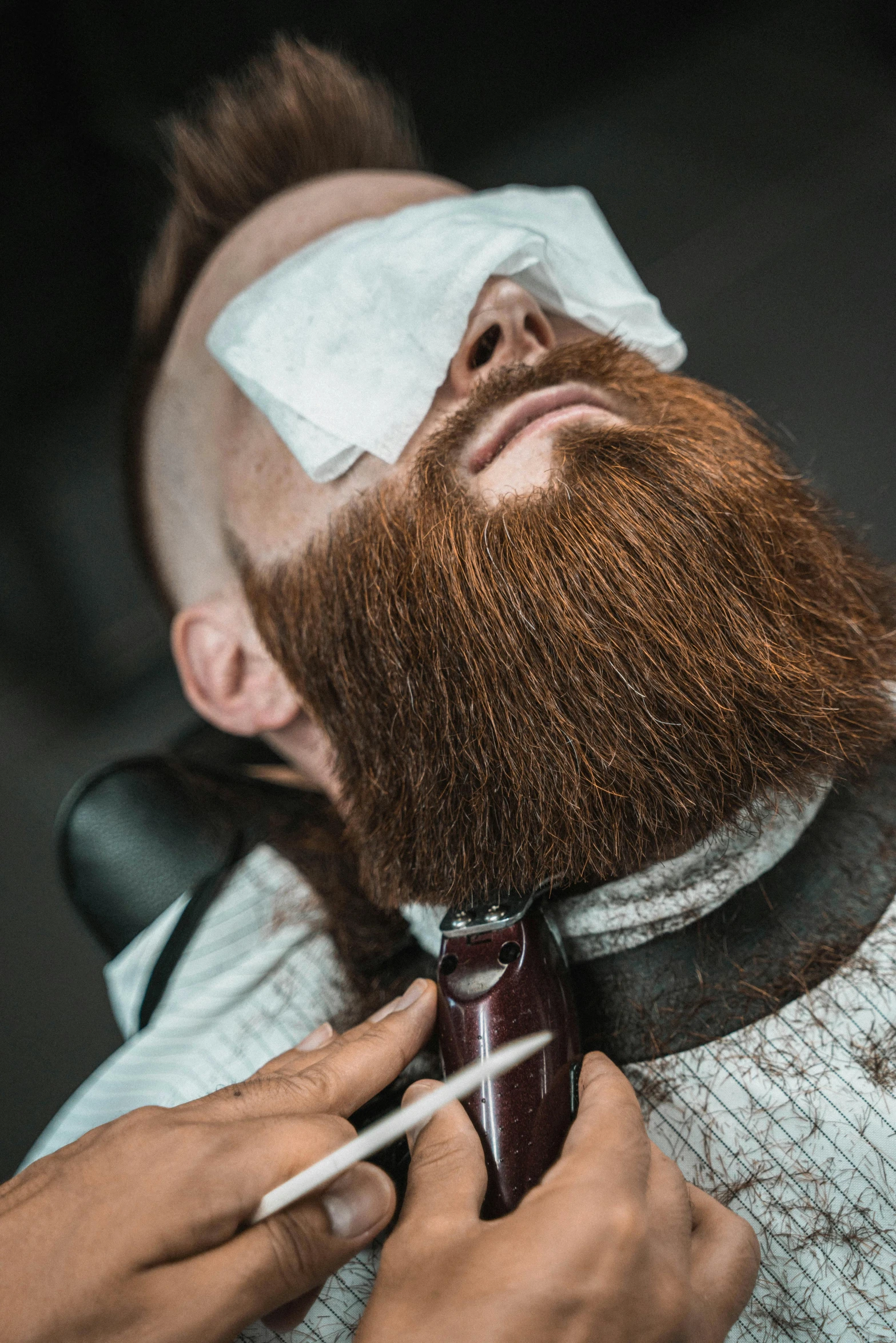 a close up of a person cutting a man's beard, an album cover, trending on pexels, ( redhead, eye patch, hairy, game ready