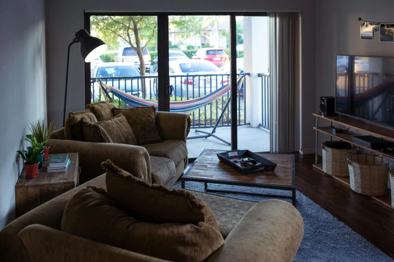 a living room filled with furniture and a flat screen tv, a portrait, unsplash, balcony door, 3 5 mm photo, chilling 4 k, dwell