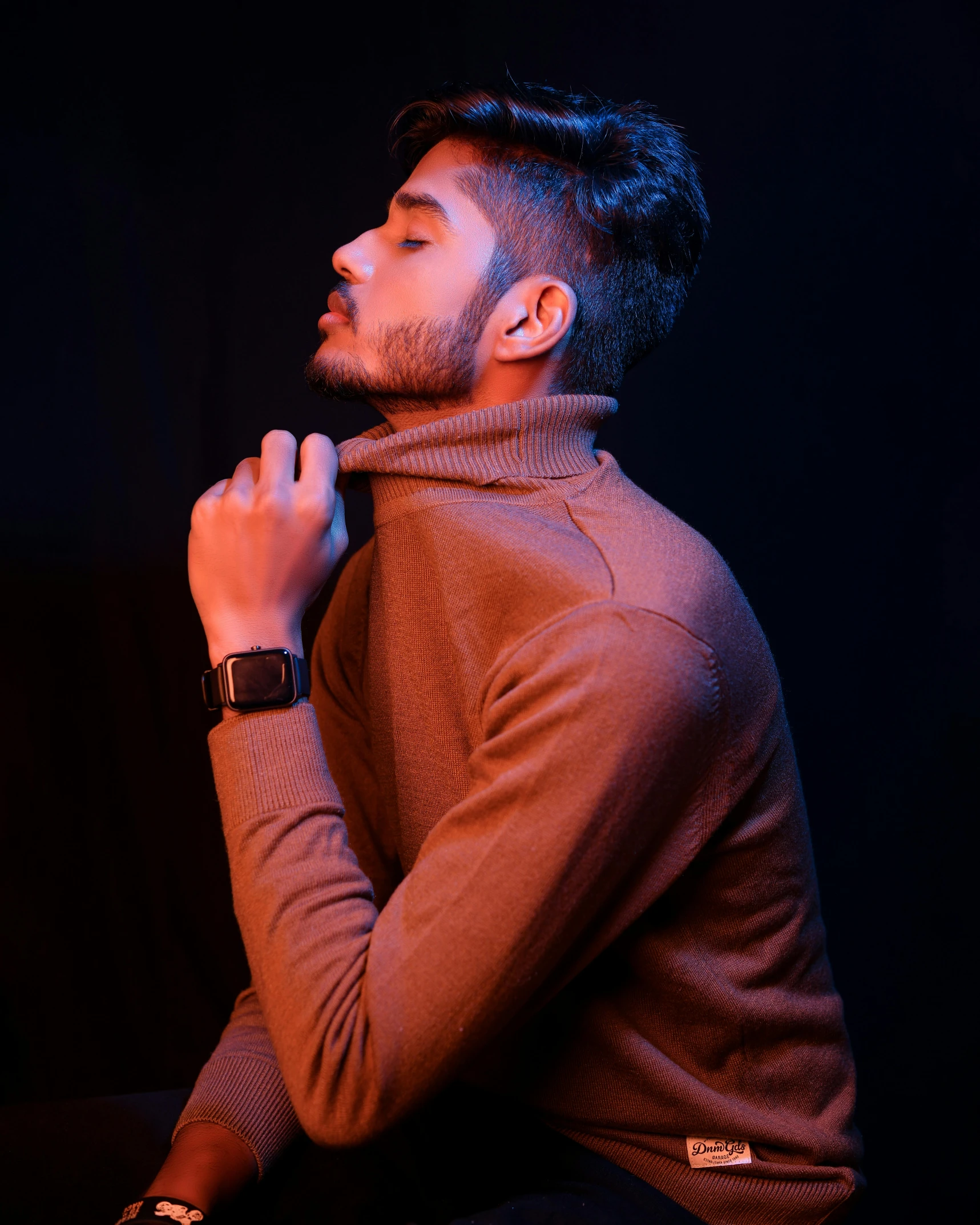 a man that is sitting down with his hand on his neck, by Cosmo Alexander, trending on pexels, romanticism, brown sweater, model standing pose, bisexual lighting, provocative indian