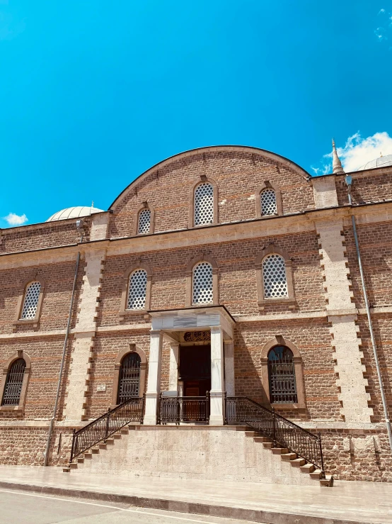 a large brick building sitting on the side of a road, mosque synagogue interior, highly upvoted, profile image, sky blue