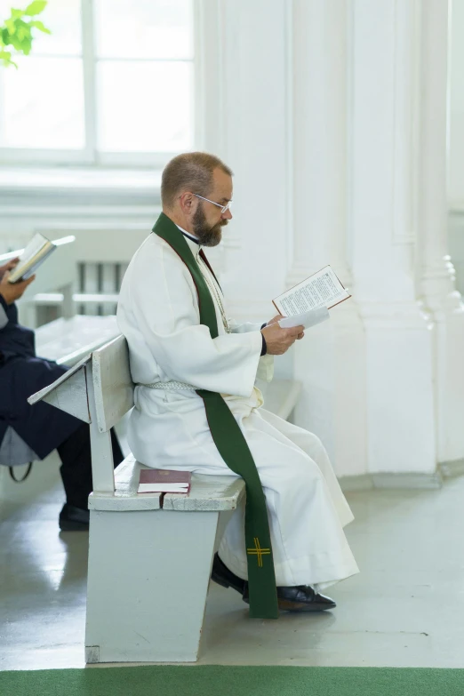 a priest sitting on a bench reading a book, two buddies sitting in a room, in russia, lgbtq, baptism