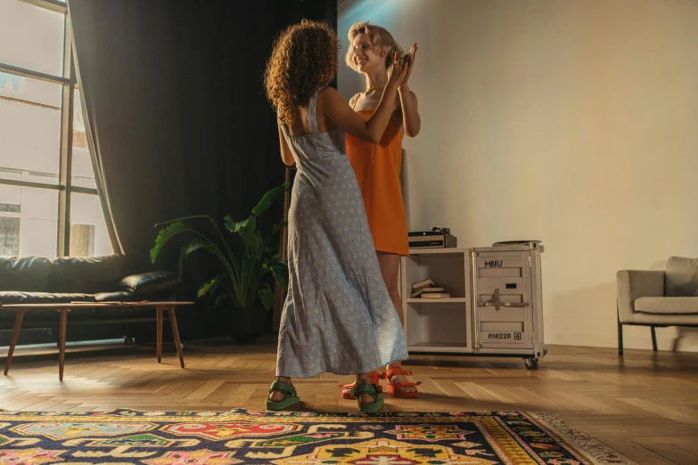 a couple of women standing on top of a wooden floor, trending on pexels, hyperrealism, rug, dancing with each other, multi - coloured, [ theatrical ]