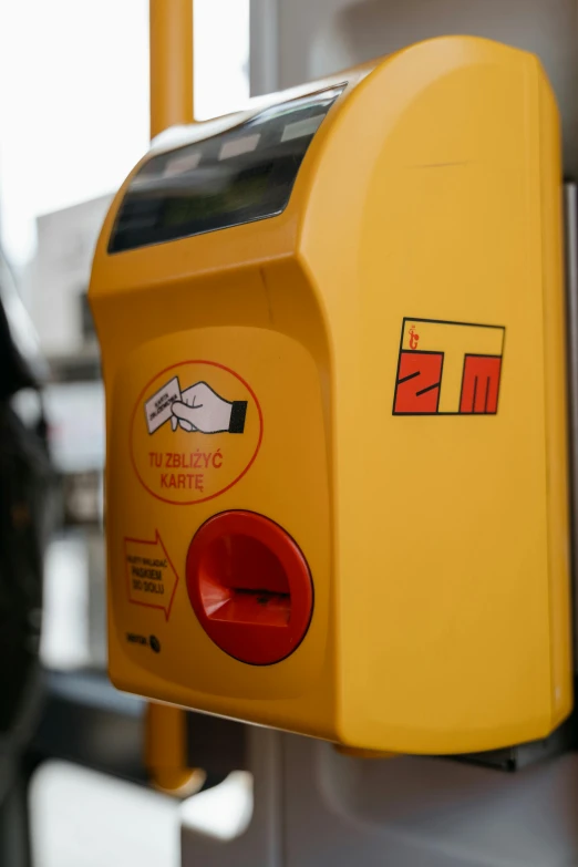 a close up of a parking meter on a bus, by Adam Marczyński, first aid kit, yellow and red, robot's heart-shaped fingers, turkey