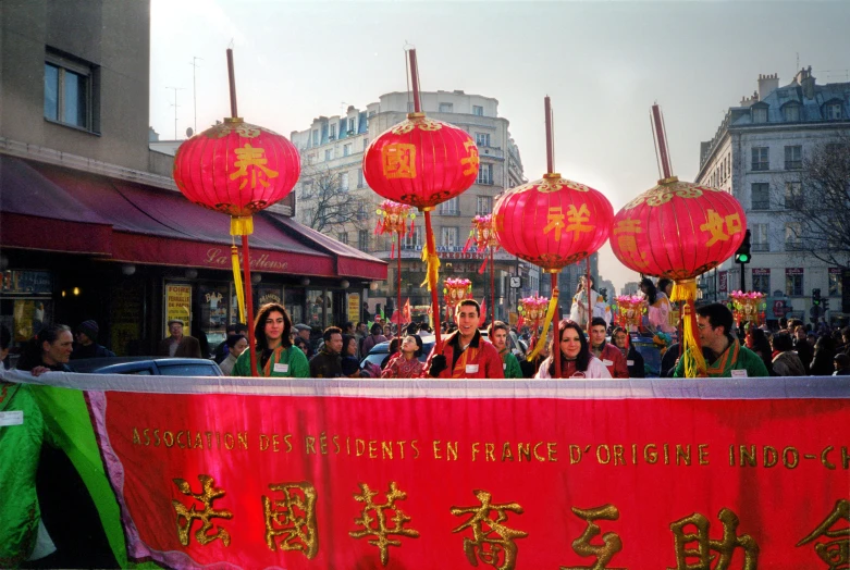 a group of people standing in front of a red banner, parade, prefecture streets, in 2 0 0 2, with paper lanterns