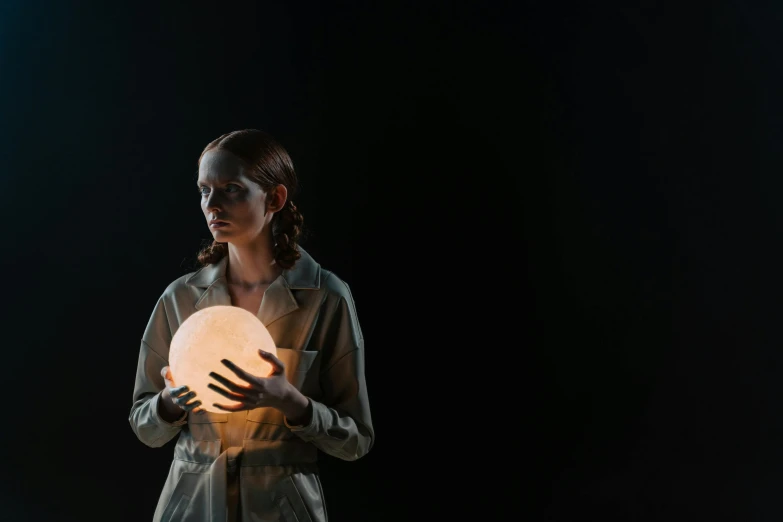 a woman holding a glowing ball in her hands, inspired by Anna Füssli, big moon, production photo, dark backdrop, elliot alderson