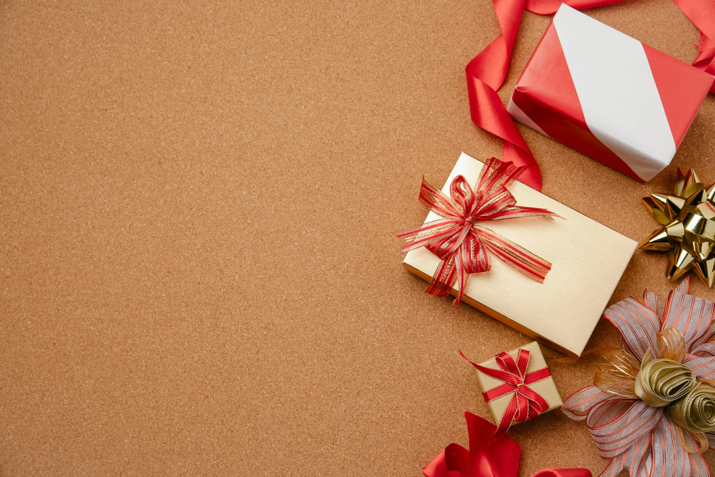 a bunch of presents sitting on top of a table, by Carey Morris, trending on pexels, visual art, gold and red, brown, background image, ribbon