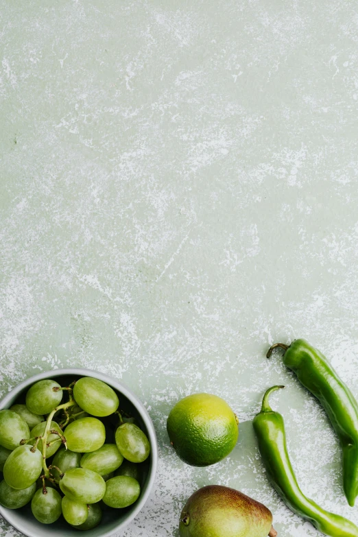 a table topped with bowls of fruit and vegetables, lime green, background image, pepper, grey