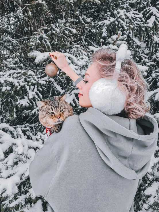a little girl playing with a cat in the snow, a colorized photo, by Julia Pishtar, trending on pexels, young woman with lynx head, listening to music, 🌲🌌, grey and silver