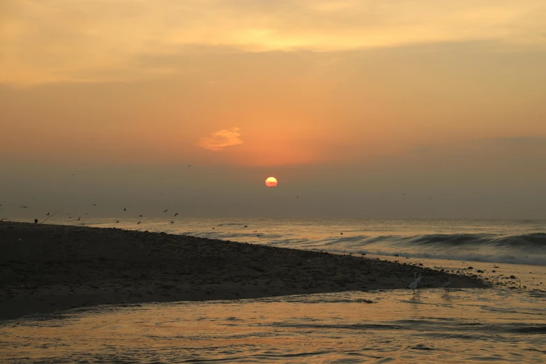 the sun is setting over the water at the beach, by Jan Tengnagel, pexels contest winner, in a sunset haze, gulf, slide show, 2000s photo