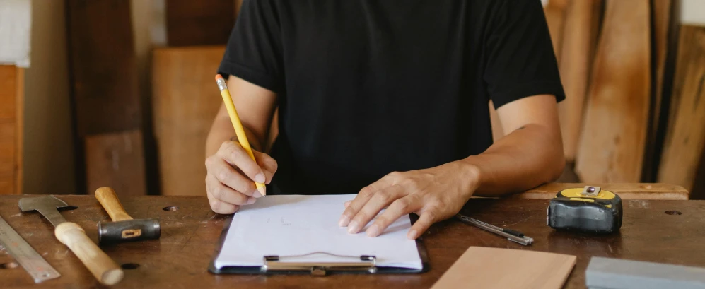 a man sitting at a table writing on a piece of paper, a drawing, pexels contest winner, holding notebook, lachlan bailey, thumbnail, no - text no - logo