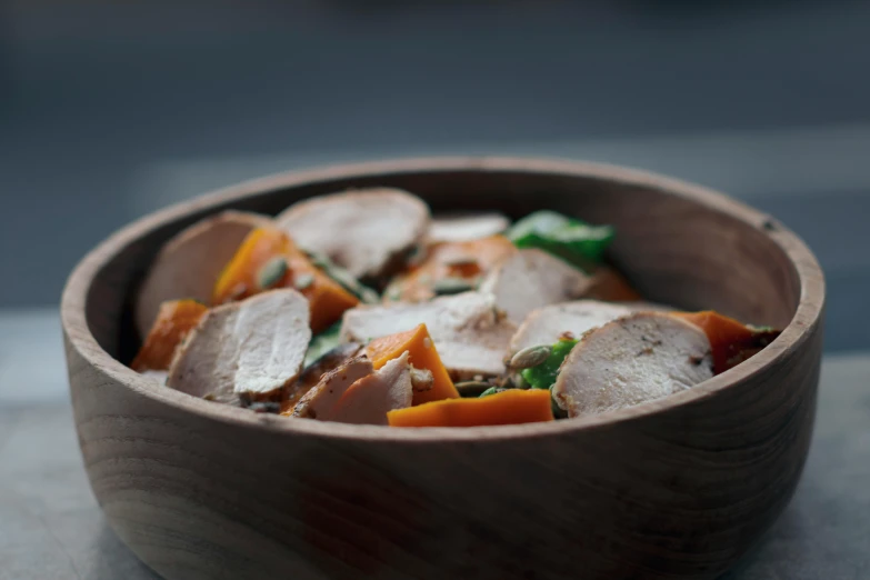 a wooden bowl filled with meat and vegetables, by Emma Andijewska, pexels contest winner, gray and orange colours, chicken, smooth light from upper left, thumbnail