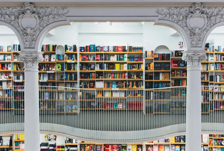 a large library filled with lots of books, pexels contest winner, steel archways, cronenberg bookshop, white space in middle, instagram post