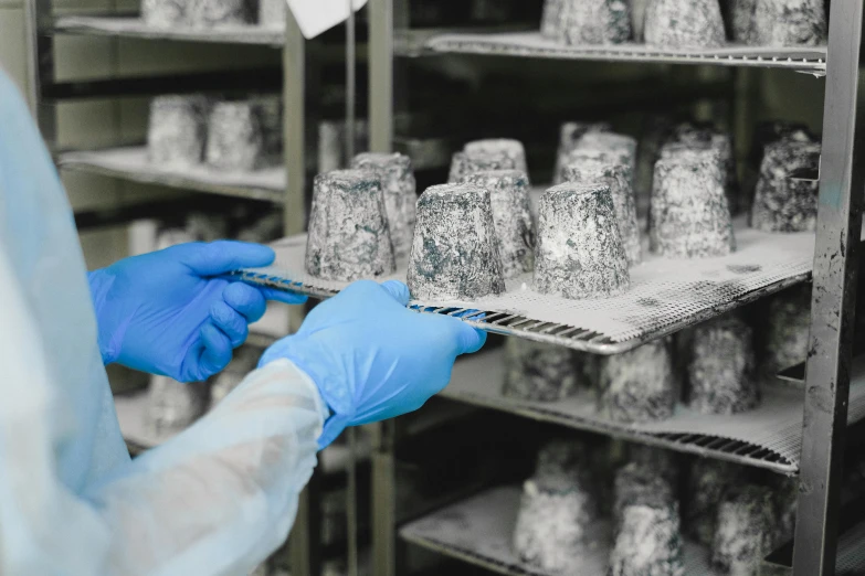 a person in blue gloves holding a tray of food, many cryogenic pods, introduction factory photo, thumbnail, greys