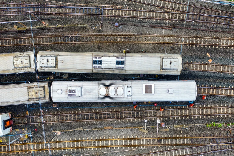 a couple of trains sitting on top of train tracks, pexels contest winner, photorealism, birds eye overhead perspective, under repairs, panoramic shot, drone photograpghy