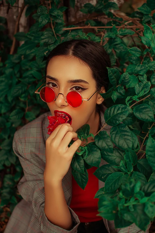 a woman with heart shaped glasses eating a strawberry, inspired by Elsa Bleda, trending on pexels, clad in vines, fashion photoshoot, with square glasses, attractive photo