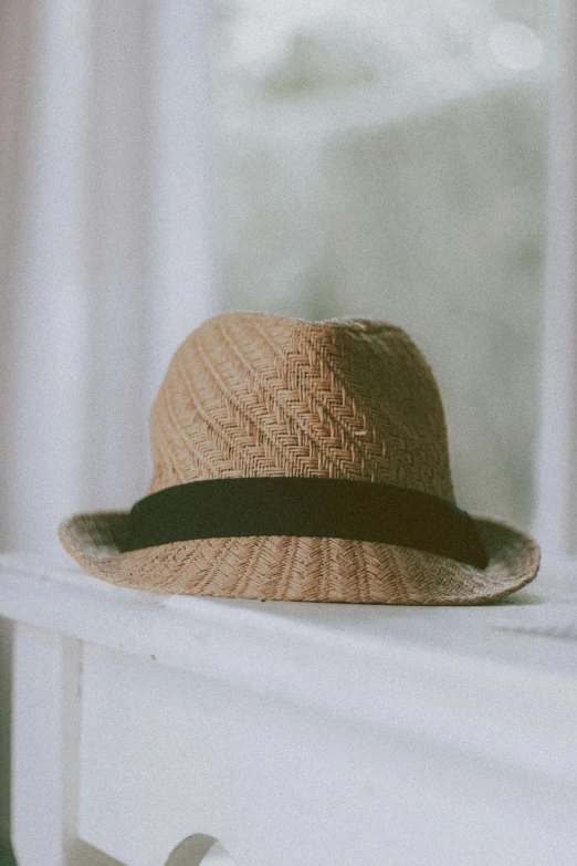 a hat sitting on top of a window sill, by Carey Morris, unsplash, close-up product photo, straw, medium format. soft light, listing image
