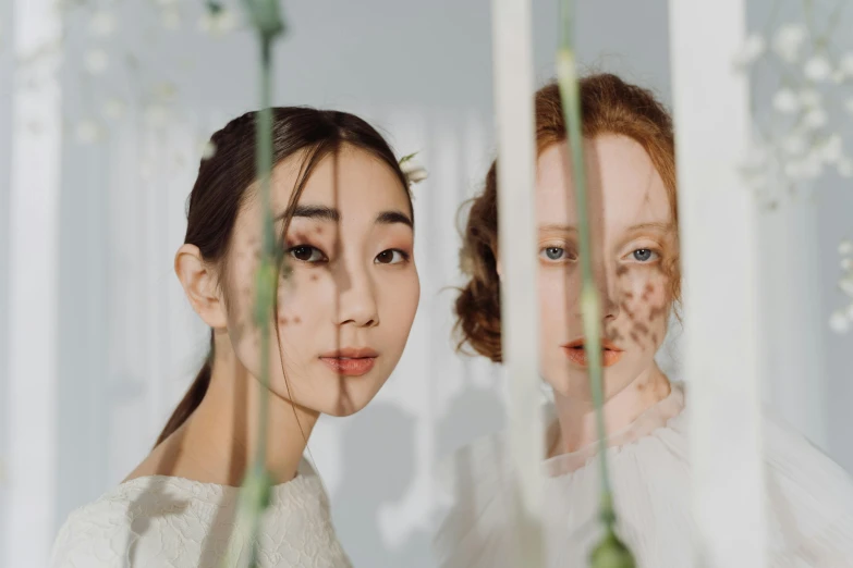 two women standing next to each other in front of a mirror, inspired by Fei Danxu, trending on pexels, rococo, slit pupils, twigs, teamlab, close up portrait photo