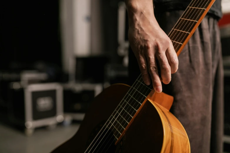 a close up of a person holding a guitar, studio spotlight, hands not visible, touring, lit from the side