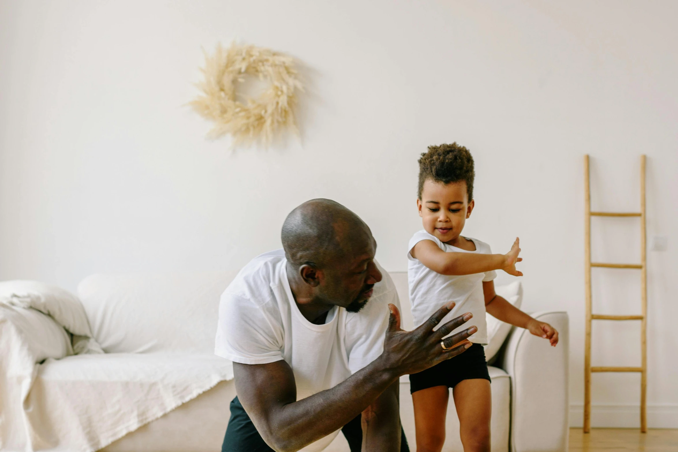 a man playing with a child in a living room, by Arabella Rankin, pexels contest winner, he is dancing, plain background, chocolate, healthcare