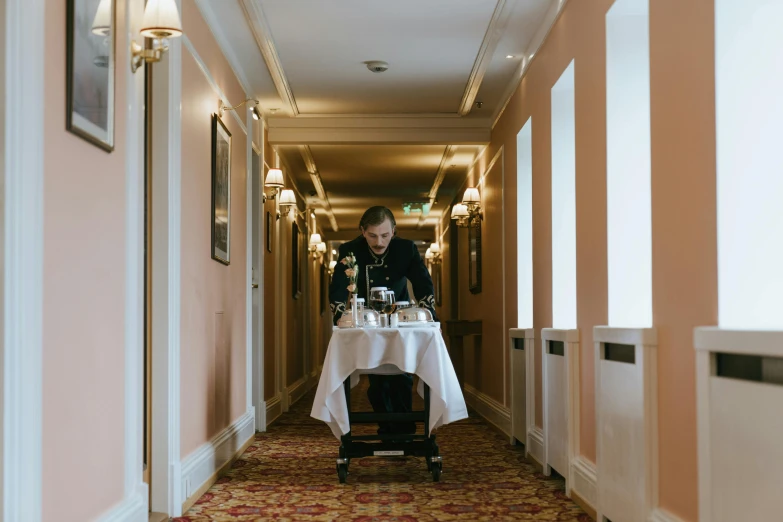 a person sitting at a table in a hallway, fine dining, leaving a room, in scotland, multiple stories