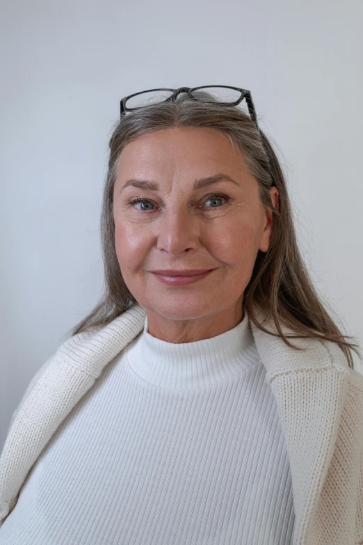 a woman wearing a white sweater and glasses, straight grey hair, magdalena andersson, on clear background, portait image