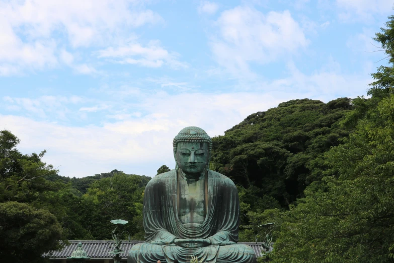 a large statue sitting on top of a lush green field, pexels contest winner, sōsaku hanga, kamakura scenery, 🚿🗝📝