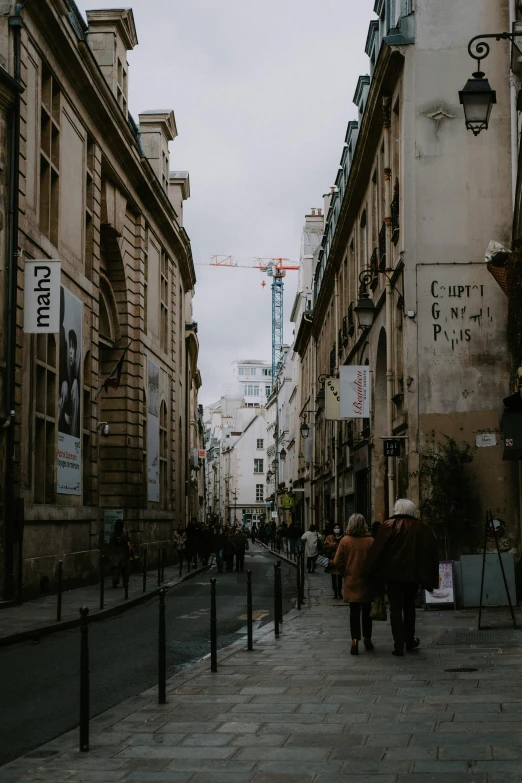 a group of people walking down a street next to tall buildings, pexels contest winner, paris school, construction, quaint, background image, high resolution photo