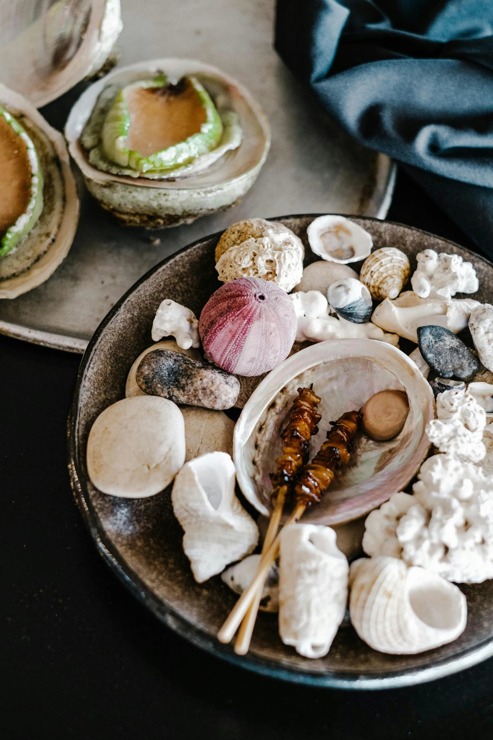 a plate of food sitting on top of a table, by Elizabeth Durack, unsplash, process art, shells and barnacles, zen garden, fossil ornaments, spa