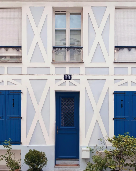 a white and blue house with blue shutters, inspired by Albert Paris Gütersloh, unsplash, paris school, lots de details, gif, architectural digest photo, 3 doors