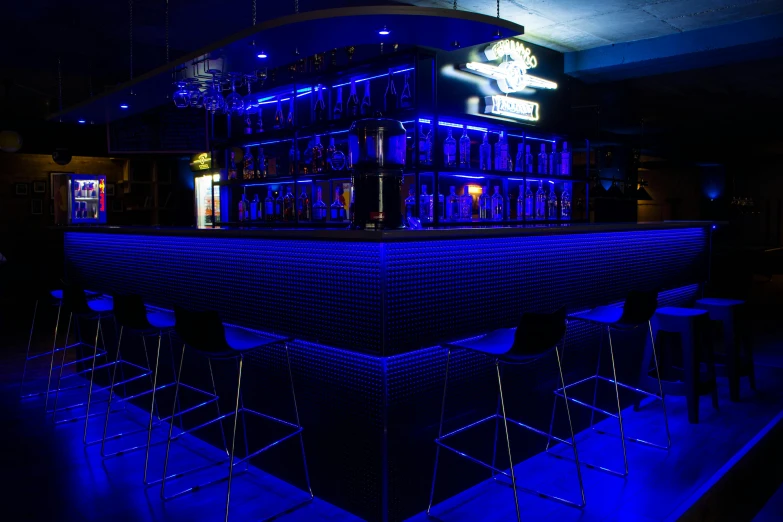 a group of stools sitting in front of a bar, deep blue lighting, gentleman's club lounge, profile image, jerez